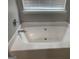 Bathroom featuring a large bathtub with tile surround and natural light at 165 Lakeside Pt, Covington, GA 30016