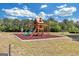 Community playground features wooden climbing structure, slide, and monkey bars, all on a mulch bed at 165 Lakeside Pt, Covington, GA 30016
