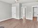 Spacious bedroom with wood floors and multiple doorways, plus white trim, baseboards, and doors and a neutral color palette at 209 Langshire Dr, Mcdonough, GA 30253