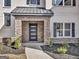 Close-up of a modern front door featuring stone accents and manicured landscaping at 209 Langshire Dr, Mcdonough, GA 30253