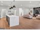 An open-concept living space connecting the kitchen island with the modern fireplace, hardwood floors, and living room area at 209 Langshire Dr, Mcdonough, GA 30253