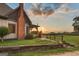 Charming home exterior with a brick chimney, wooden porch, and landscaped yard at sunset at 1694 Mount Bethel Rd, Mcdonough, GA 30252