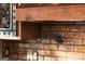 Close-up of a brick kitchen wall showing decorative wood cabinets and pot filler at 1694 Mount Bethel Rd, Mcdonough, GA 30252