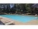 A clear, blue outdoor community pool surrounded by lounge chairs and a wooded area at 3075 Wood Valley Dr, Mcdonough, GA 30253