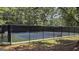 A fenced tennis court surrounded by trees at 3075 Wood Valley Dr, Mcdonough, GA 30253