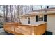 Back deck featuring wood railings, an access door, and siding that blends into a wooded landscape at 6255 James Rd, Austell, GA 30168