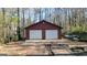 A detached two-car garage offers extra storage and parking, set against a wooded backdrop at 6255 James Rd, Austell, GA 30168