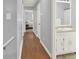 Hallway with wood floors leads to a bedroom and bathroom at 6255 James Rd, Austell, GA 30168