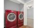Brightly-colored red front-load washer and dryer machines are featured in the laundry area at 6255 James Rd, Austell, GA 30168