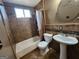 Bathroom with a tile tub and shower, a toilet, and a pedestal sink at 6160 Great Oaks Dr, Lithonia, GA 30058