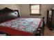 Bedroom features a large, ornate bed frame and a quilt with a colorful pattern at 6160 Great Oaks Dr, Lithonia, GA 30058