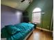 Vaulted bedroom featuring colorful walls, hardwood floors, and a large window at 6160 Great Oaks Dr, Lithonia, GA 30058
