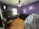 Bedroom with purple walls, hardwood floors, a fan, and a large window at 6160 Great Oaks Dr, Lithonia, GA 30058