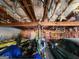 Cluttered garage with exposed insulation, storage, and a dark colored sedan at 6160 Great Oaks Dr, Lithonia, GA 30058