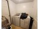 A compact laundry room with a white washer and dryer and a door at 6160 Great Oaks Dr, Lithonia, GA 30058