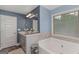 Bright bathroom features double sinks, large mirror, neutral walls, and a jetted tub at 275 Bramble Bush Trl, Covington, GA 30014