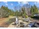 Backyard with patio, chairs, and lush trees with a view of the rear exterior of the home at 4569 Chatsworth Ovrlk Ne, Roswell, GA 30075