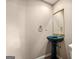 Powder room with a blue pedestal sink, gold fixtures, and decorative mirror at 4569 Chatsworth Ovrlk Ne, Roswell, GA 30075