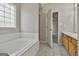 Bathroom featuring a bathtub, shower, double sink vanity, and doorway in a well-lit space at 12241 Crestwood Ct, Fayetteville, GA 30215