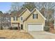 Two-story home with a two-car garage, tan stucco, and attractive stone facade accents at 12241 Crestwood Ct, Fayetteville, GA 30215