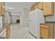 Kitchen showing wooden cabinets, white appliances, and view to the living room fireplace at 12241 Crestwood Ct, Fayetteville, GA 30215