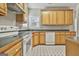 Traditional kitchen featuring wood cabinetry, white appliances, and neutral countertops at 12241 Crestwood Ct, Fayetteville, GA 30215