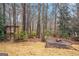 Wooded backyard with stone fire pit and pergola; an inviting outdoor living space at 149 Crown Oaks Dr, Stockbridge, GA 30281
