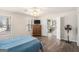 Well-lit bedroom featuring wood floors, ceiling fan, and view into hall with staircase at 149 Crown Oaks Dr, Stockbridge, GA 30281