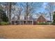 Charming brick home with a covered front porch and mature trees on a large lawn at 149 Crown Oaks Dr, Stockbridge, GA 30281