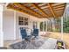 Covered patio with string lights, comfortable seating, and a peaceful backyard view at 149 Crown Oaks Dr, Stockbridge, GA 30281