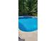 In-ground pool with vibrant blue water and patio furniture around the perimeter at 149 Crown Oaks Dr, Stockbridge, GA 30281