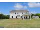 Expansive backyard featuring a covered patio, lush lawn, and white two-story house at 127 Felicity Pike, Locust Grove, GA 30248