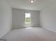Bright, carpeted bedroom offering ample natural light from the nearby window at 127 Felicity Pike, Locust Grove, GA 30248