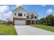 Striking two-story home boasting a brick and shingle exterior, a spacious two-car garage, and a pristine lawn at 127 Felicity Pike, Locust Grove, GA 30248