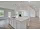 Bright, modern kitchen features a large island with quartz countertop and views to the living room fireplace at 127 Felicity Pike, Locust Grove, GA 30248