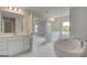 Elegant bathroom with double vanities, soaking tub, and views to the main bedroom at 127 Felicity Pike, Locust Grove, GA 30248