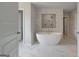 Luxurious bathroom features a freestanding tub, marble tile, and separate shower at 127 Felicity Pike, Locust Grove, GA 30248