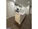 Open-concept kitchen with granite counters, stainless appliances, white cabinets, and center island with sink at 11144 Cornerstone Way, Hampton, GA 30228