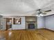 Inviting living room with beautiful hardwood floors, stone fireplace, and classic ceiling fan with light fixture at 114 Mcbride Rd, Fayetteville, GA 30215