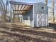 Covered outbuilding featuring gray plank siding with sliding barn doors, providing ample space for storage or workshop activities at 114 Mcbride Rd, Fayetteville, GA 30215