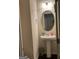 A compact bathroom with a pedestal sink, decorative mirror, and neutral wall color at 6001 Nile Ct, Atlanta, GA 30349