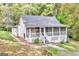 Quaint single-story home featuring a screened porch, with a green lawn and natural wooded surroundings at 4481 Mclain Cir, Acworth, GA 30101