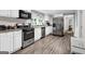 Modern kitchen with stainless steel appliances, white cabinets and new flooring, perfect for cooking and entertaining at 4481 Mclain Cir, Acworth, GA 30101
