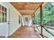 Covered porch with wooden floor, safety railing and an entrance door at 4481 Mclain Cir, Acworth, GA 30101