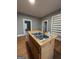 Kitchen island with stainless steel sink, wooden cabinets and view to open doorway at 18 Laurel St, Covington, GA 30014