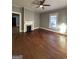 Large, empty living room featuring hardwood floors, gray walls, fireplace and ceiling fan at 18 Laurel St, Covington, GA 30014