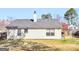 Exterior view of home's backyard featuring a shingled roof, chimney, lawn, and wood fence at 255 Brandon Ridge Cir, Stockbridge, GA 30281