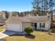 Charming single-story home featuring a two-car garage, well-manicured lawn, and mature trees at 255 Brandon Ridge Cir, Stockbridge, GA 30281