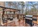 Wooden deck with gazebo, outdoor seating, and grill overlooking the backyard at 65 Ashland Grove Ct, Sharpsburg, GA 30277
