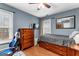 This bedroom includes wooden floors, a ceiling fan, a twin bed, and a television at 65 Ashland Grove Ct, Sharpsburg, GA 30277